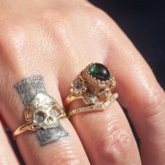 A garden snake wraps around a skull resting in a bed of flowers in an allegory come to life that you can wear on your finger. Named Nozarashi, Japanese for "weather beaten bones" in a twist on traditional memento mori rings. A snake for shedding old ways, flowers for growth, and an open minded skull to live life to the fullest. One of a kind and handmade in solid 14k yellow gold by Nick Potash in his Maui, Hawaii Studio. Unheated green sapphire cabochon brain (1.8ct), violet sapphire flowers, or Dark Purple Rings, Luxury Antique Black Rings, Aesthetic Vintage Rings, Sofia Zakia, Weird Engagement Rings, Strange Rings, Memento Mori Ring, Unusual Wedding Rings, Gold Skull