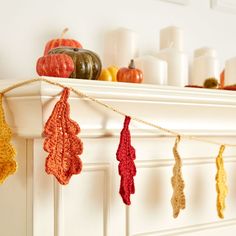 knitted autumn leaves hanging from a mantle