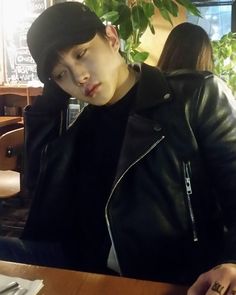 a young man sitting at a table in front of a plate with food on it