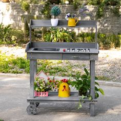 a potted plant sitting on top of a metal cart next to a garden area