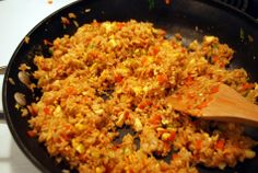 rice and vegetables cooking in a skillet on the stove