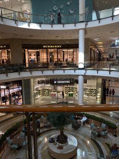 the inside of a shopping mall with people walking around