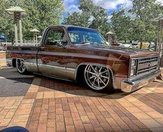 a brown truck parked on top of a brick road