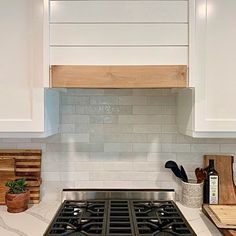 a stove top oven sitting inside of a kitchen next to wooden cutting boards and utensils