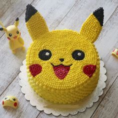 a pokemon cake with pikachu figurines around it