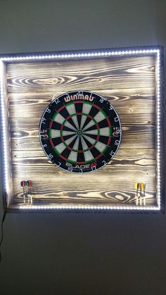 a lighted sign with darts in the center