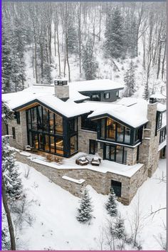 an aerial view of a large house in the woods with snow on the ground and trees around it