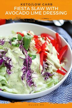 a white bowl filled with lettuce and red peppers next to a blue towel