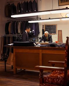 two men sitting at a desk in an office