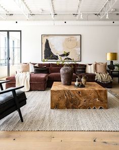 a living room filled with furniture and a large painting hanging on the wall above it