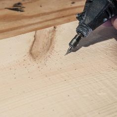 a person is using a drill to cut wood with a screwdriver on it