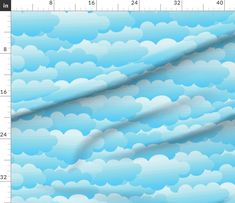 a blue sky with clouds on it is shown from the side, as well as a ruler