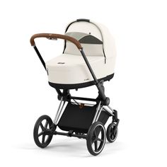 the buggy stroller is shown in white and black, with a wooden handlebar