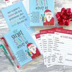 santa's secret santa activity kit on a table next to some christmas cards and a pen