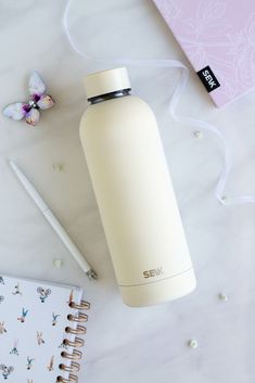 a white water bottle sitting next to a notebook