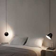 a bed with two lamps hanging over it