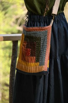 a woman's handbag hanging from the back of her dress, with trees in the background