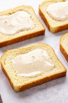 four slices of bread with cream cheese spread on them