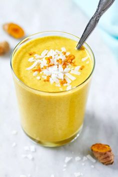 a smoothie in a glass topped with coconut flakes