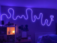 a purple room with neon lights on the wall and a bed in front of it