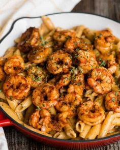 pasta with shrimp and parmesan in a red skillet on a wooden table