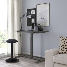 a living room with a couch, chair and computer desk in front of a window