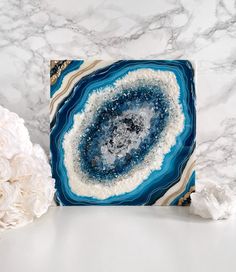 a blue and white marble coaster sitting on top of a table next to some flowers