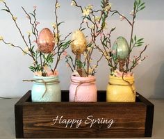 three mason jars with flowers in them and the words happy spring written on one side