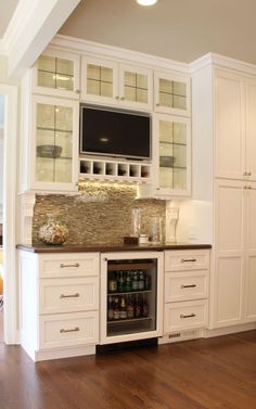 a kitchen with wooden floors and white cabinets