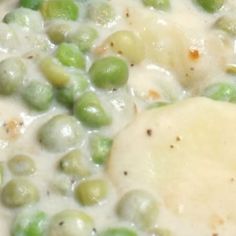 peas and cheese are mixed together in a white sauce