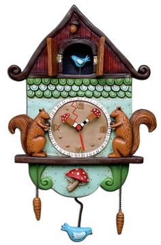 a clock that is on the side of a wall with two cats sitting on it