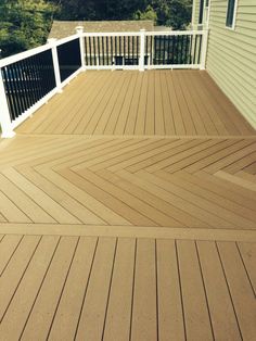 a wooden deck with white railing and black rails