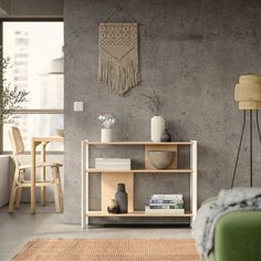 a living room with a couch, table and chair next to a wall hanging on the wall