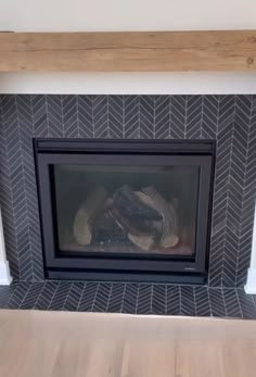 a fire place with a wood mantle and tile