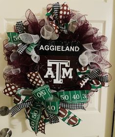 this wreath is decorated with footballs and the words, aggieland on it