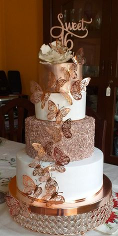 there is a three layer cake with butterflies on it