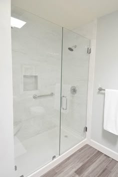 a white bathroom with a glass shower door