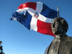 a statue with a flag flying in the background