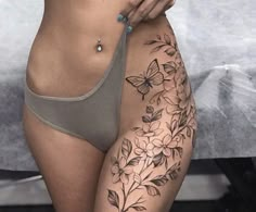 a woman's stomach with tattoos on it and flowers in the bottom half of her body