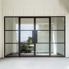 an empty room with glass doors and white walls