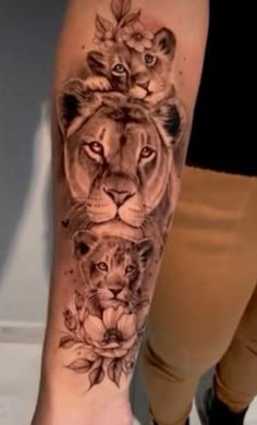 a woman's leg with a lion and flowers tattoo on it