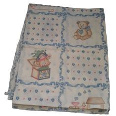 the blanket has teddy bears on it and is white with blue trimmings,