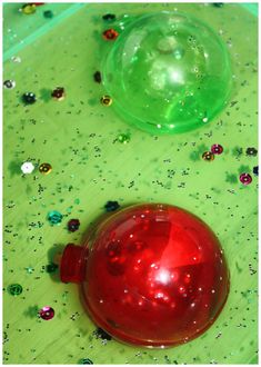 a red ball sitting on top of a green table covered in confetti and beads