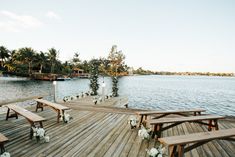 a wooden dock with benches and flowers on it