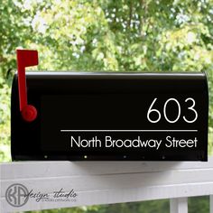 a black mailbox with the number 501 on it and a red door handle