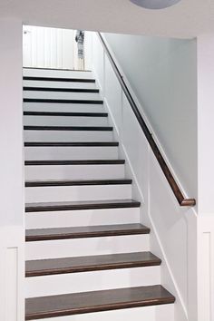 there is a white staircase with brown steps