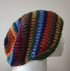 a white mannequin head wearing a multicolored crocheted knit hat