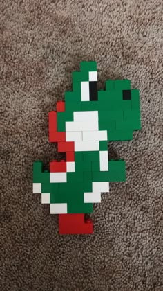 an image of a green and red mario bros toy laying on the floor with it's head turned upside down