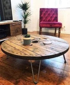 a living room with a couch, television and table in the middle on wooden flooring