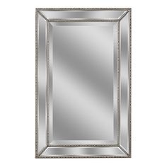 a silver framed mirror on a white wall